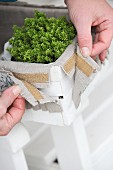 Decorating a wood chip basket with linen and decorative trim fixed with velcro
