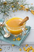 Hot orange juice with seaberries and a cinnamon stick