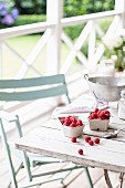 Raspberries in a small bowl on a terrace table