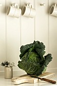 Savoy cabbage on a chopping board in a kitchen