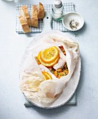 Redfish with orange slices and ginger carrots baked in parchment paper