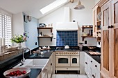 Country-house kitchen with black worksurface and vintage-style gas cooker
