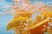 Orangenschnitze im sprudelnden Wasser