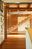 Modern wooden staircase in renovated period building with wood-beamed ceiling