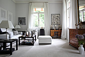 White sofa set, dark coffee tables and antique chest of drawers in lounge