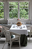 White wicker armchairs around table in conservatory