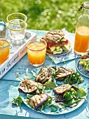 Grilled aubergine slices with a salad, a sandwich and orange juice