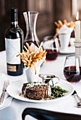 Gourmet pepper steak with french fries and red wine
