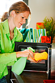 Woman cleaning microwave oven