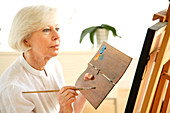 Elderly woman painting