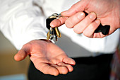 Hands passing on keys