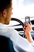 Man driving while using phone