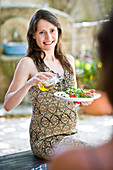 Pregnant woman adding olive oil