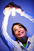 Woman putting energy saving bulb