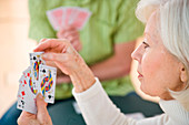 Elderly woman playing cards