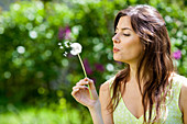 Woman blowing dandelion
