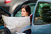 Woman driver reading a road map