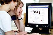 Teenagers looking Facebook