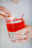 Woman taking vitamin C tablet