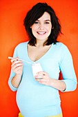 Pregnant woman eating a yogurt