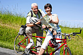 Senior couple riding tandem bicycle