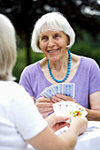 Elderly woman playing cards