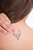 Young woman with tattoo of stag on back