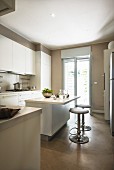 Island counter and bar stools in white, contemporary fitted kitchen