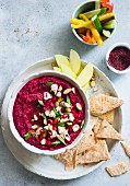 Beetroot goat cheese dip with vegetable sticks and crackers