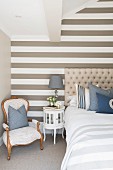 Striped accent wall in elegant bedroom in shades of beige, white and blue