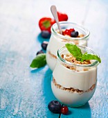 Gesundes Frühstück: Joghurt mit Müsli und Beeren in Gläsern