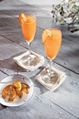 Whiskey cocktail in champagne flute with macerated peaches garnish