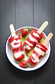 Erdbeer-Joghurt-Eis am Stiel auf einem Teller