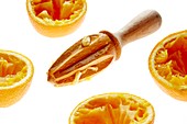 Orange halves and wooden juicer