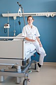 Portrait of nurse sitting on hospital bed