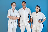 Portrait of three nurses against blue background