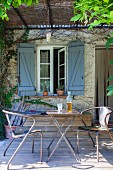 Vintage Metallstühle und Klapptisch auf rustikaler Terrasse