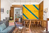 Wohnraum mit farbig gestalteter Wand und Wandvertäfelung