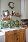 Wooden shelves and mirror with tiled surround above kitchen sink