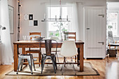 Various chairs around wooden table in bright dining room