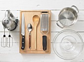 Kitchen utensils: handmixer, knife, spoon, grater, glass bowl, pot