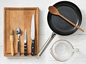 Kitchen utensils: pan, measuring cup, brush, spoon, knives