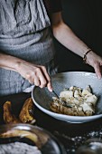 Frau zerquetscht Bananen für Banana Bread Donuts