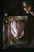 A seasoned chicken is displayed on a cutting board lined with butchers paper