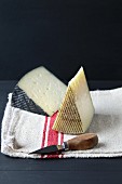 Two wedges of cheese on a kitchen cloth