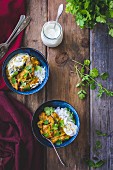 Aubergine curry with coriander and rice in bowls