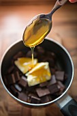 Blockschokolade, Butter und Honig in einem Topf