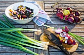 Zutaten für Linsensalat mit Obst auf einem hölzernen Gartentisch