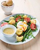 Salat mit Kartoffeln, pochiertem Ei, Rucola, Kirschtomaten und Bohnen