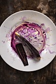 Gemüse- und Saftreste von violetten Karotten auf weißem Teller
